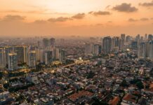 Harga Properti Jakarta Tidak Akan Pernah Turun — Ini Alasannya Skyline Jakarta dari udara menggambarkan tren harga properti yang terus naik secara struktural — analisis Panduanproperti.id